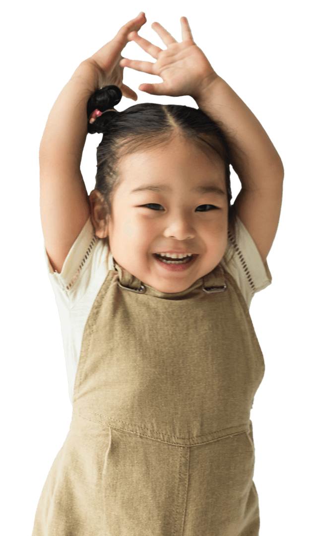 Toddler girl smiling with hands above head