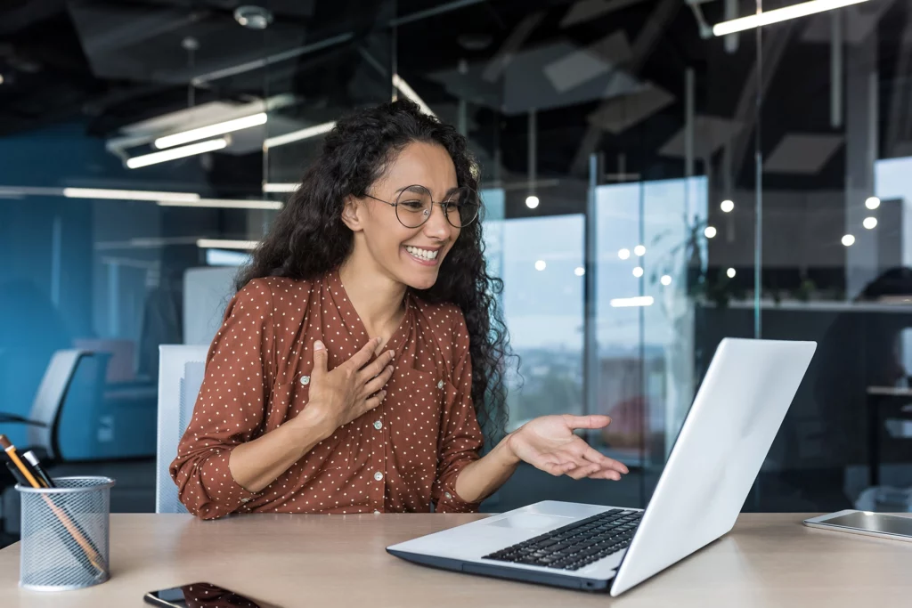 Woman looking happy and surprised on computer