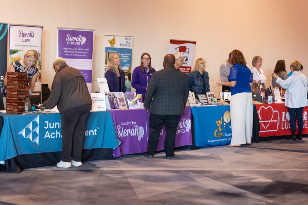 Attendees browsing nonprofit exhibitor tables in the showcase hall